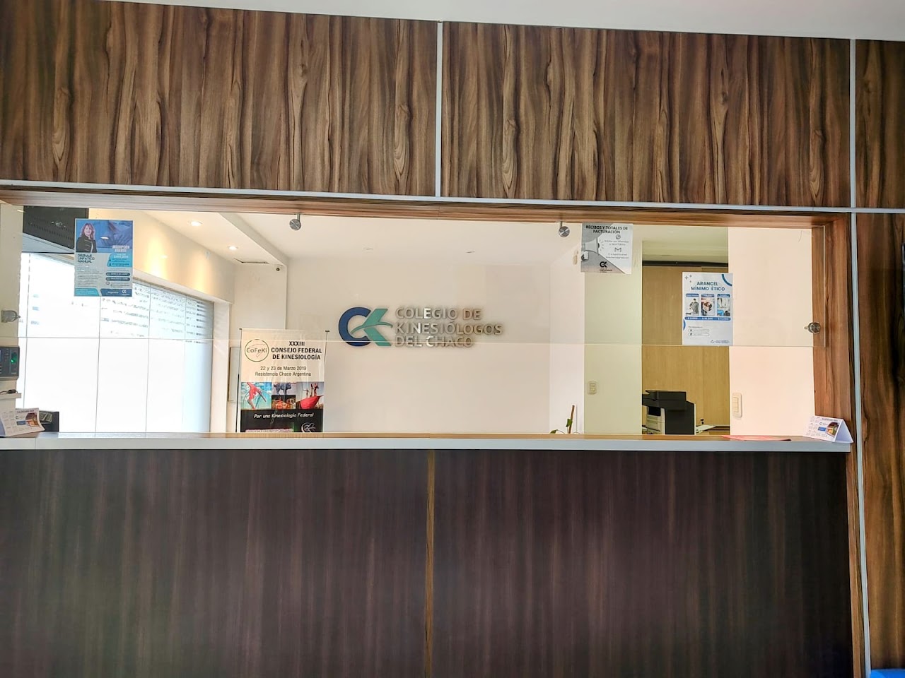 Institutional conference room and training hall for a professional healthcare association, sleek presentation screen, modern conference chairs, warm wood wall paneling, natural daylight, architectural photography.